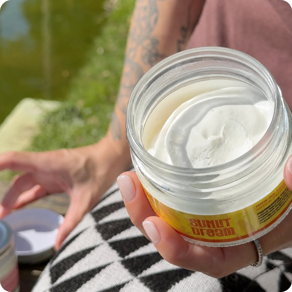 An open jar of Sunlit Dream showing the whipped white body butter inside