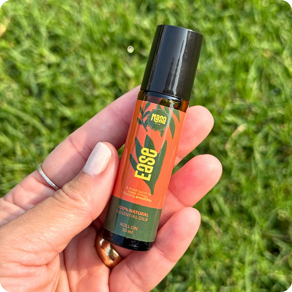 The EASE aroma roller held in one hand above grass