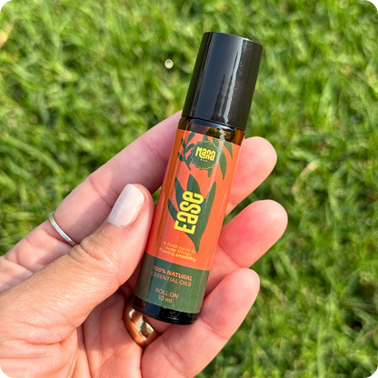 The EASE aroma roller held in one hand above grass