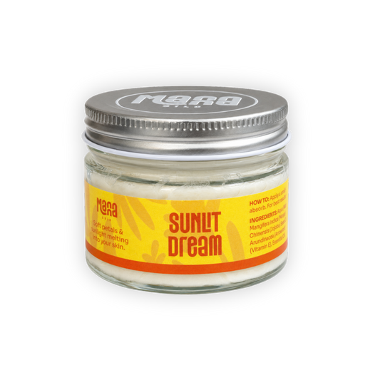 Manna Sunlit Dream body butter in a clear glass jar with a silver lid and a yellow label
